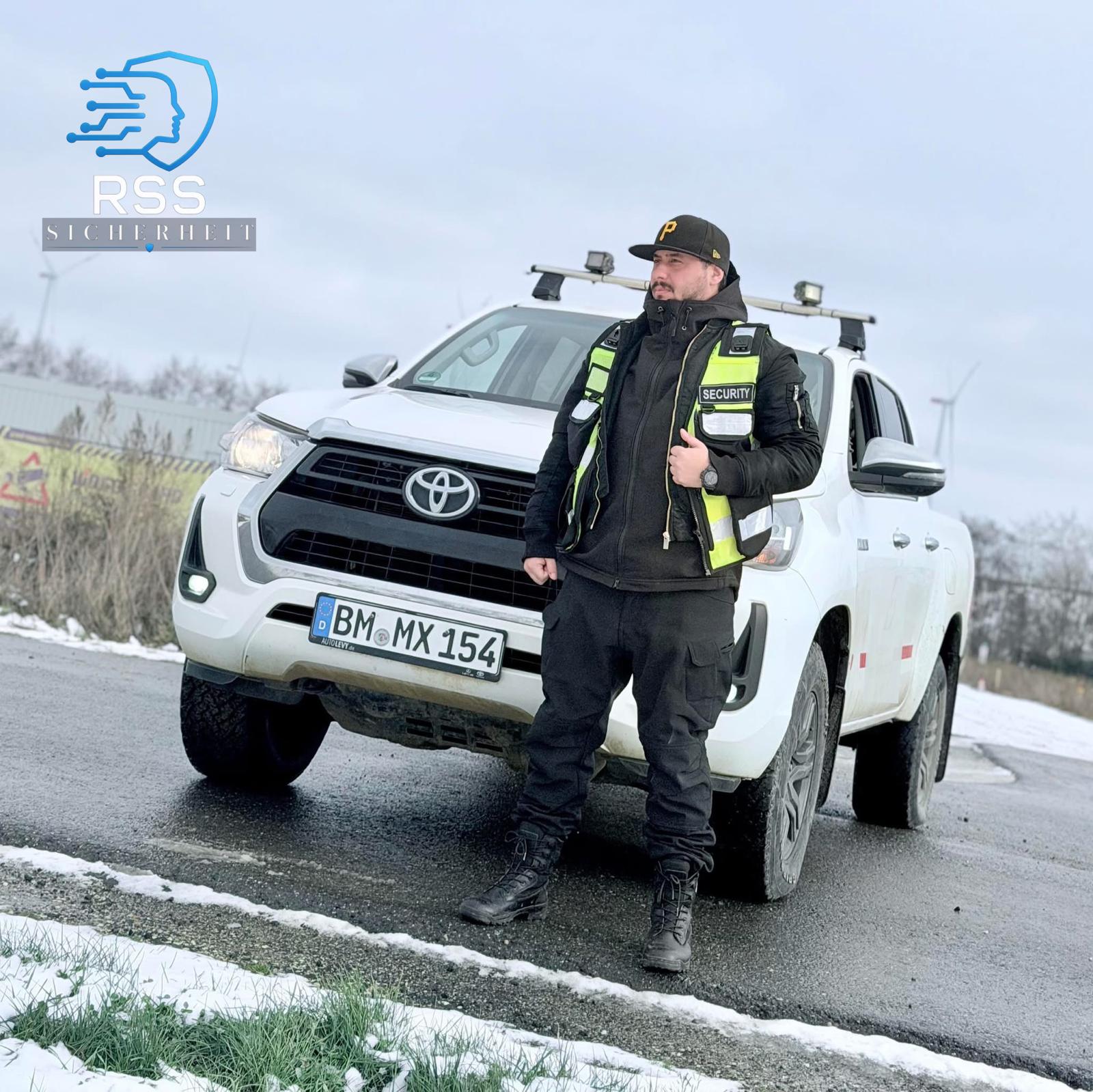 Mitarbeiter mit Bodycam vor dem Dienstfahrzeug Toyota Hilux im Winter